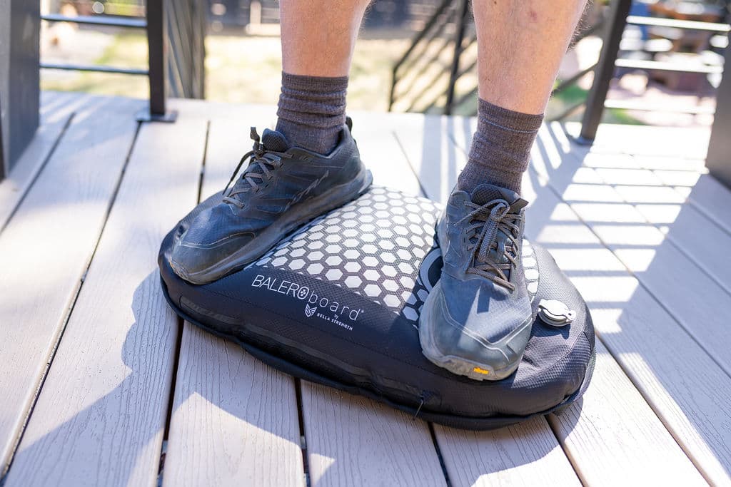Close view of two feet in running shoes standing squarely on a fully inflated BALEROboard
